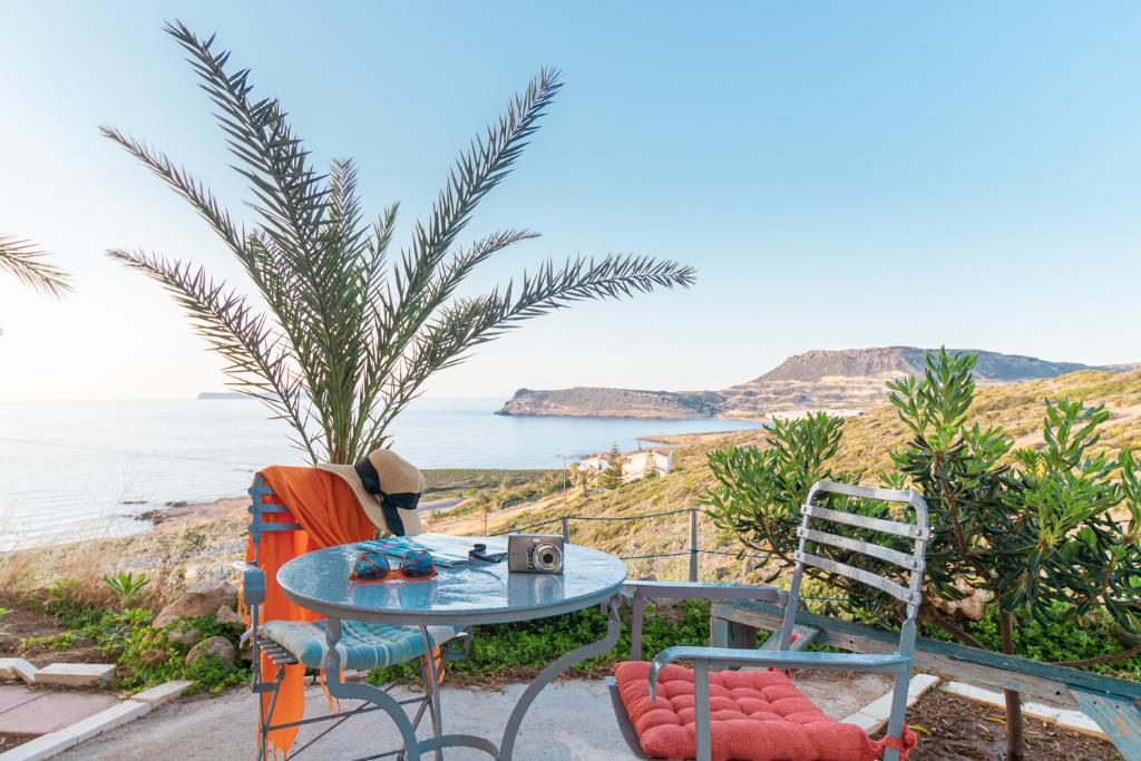 stół i krzesła siedzące obok oceanu w obiekcie Liogerma Resorts w mieście Sitia