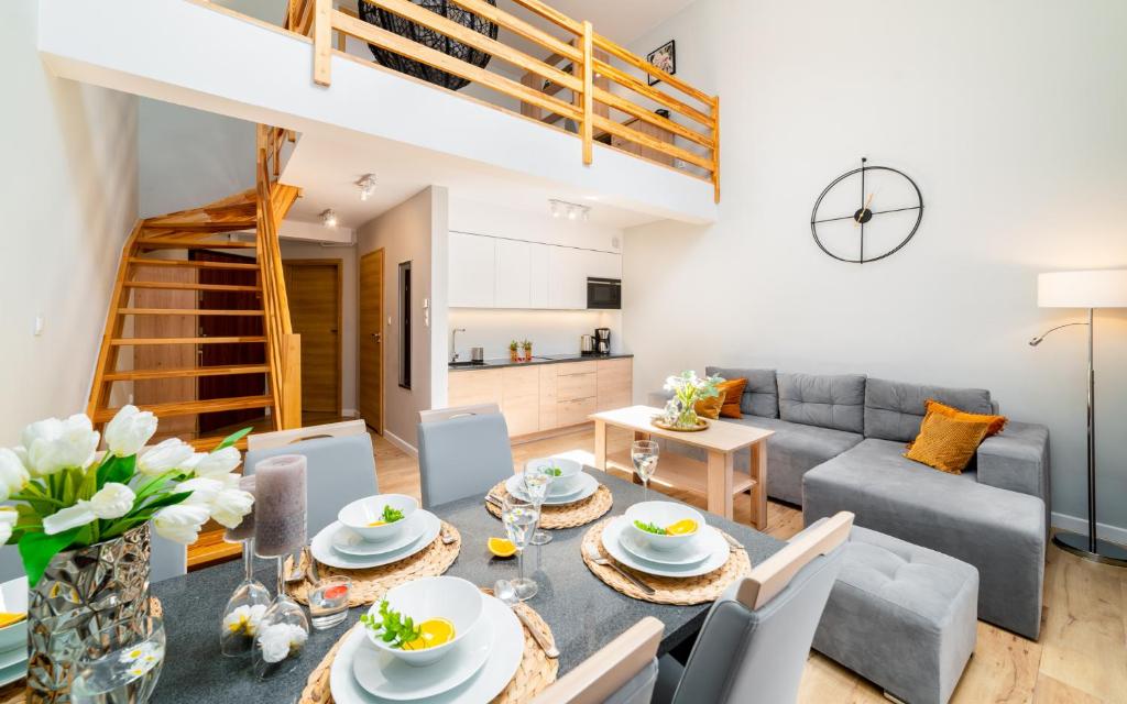 uma sala de estar com uma mesa e cadeiras e um sofá em Apartament Karkonoskie Tarasy em Karpacz
