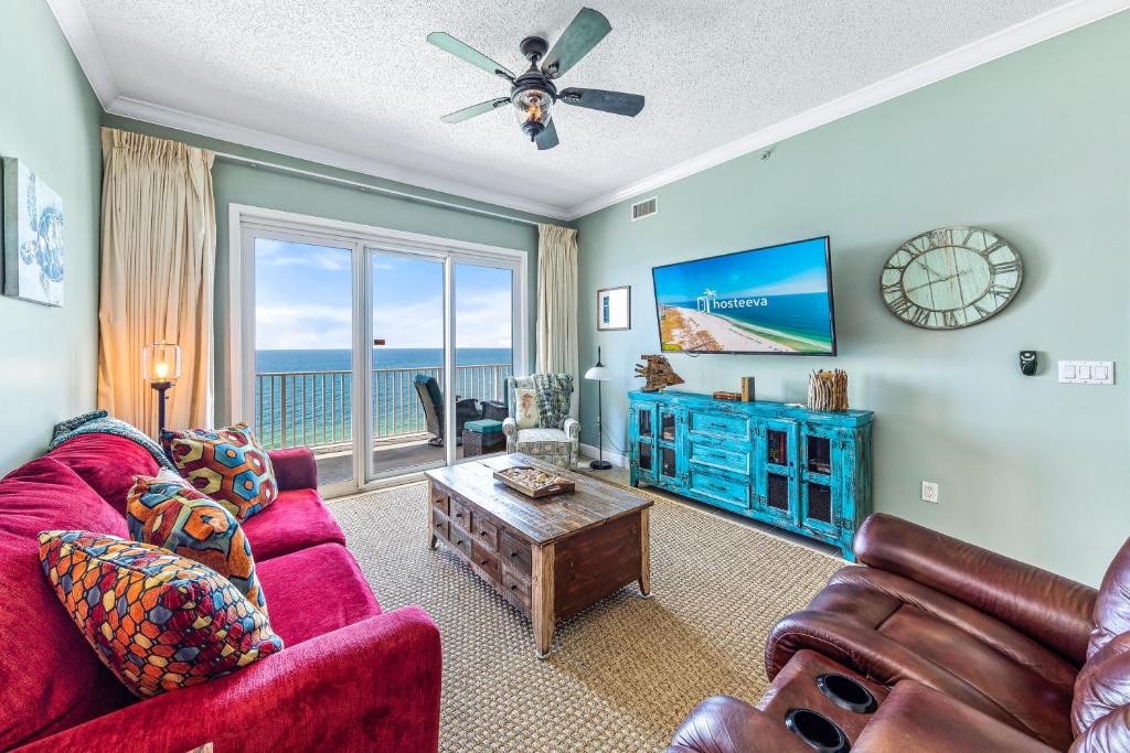 a living room with a red couch and a tv at Windemere Beachfront Condo 1503 in Perdido Key