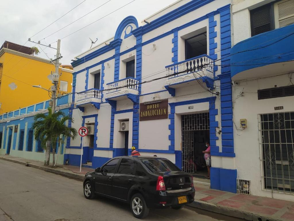 a black car parked in front of a blue and white building at Hotel Andalucía Inn in Santa Marta