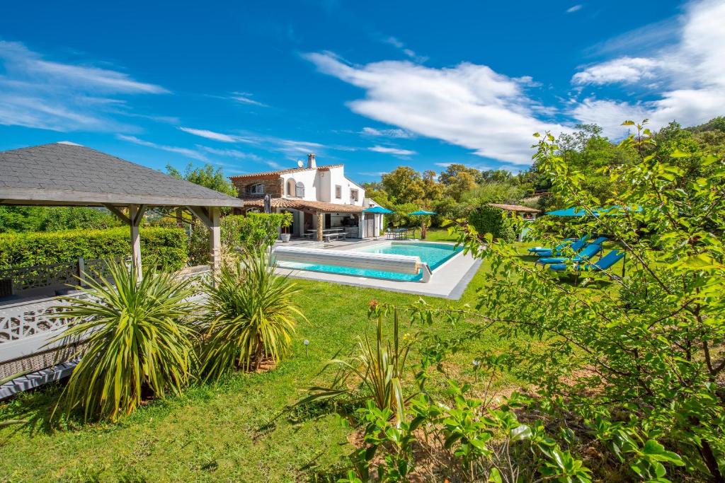 un patio trasero con piscina y una casa en Le Joyau du Golfe de St Tropez, en Cogolin