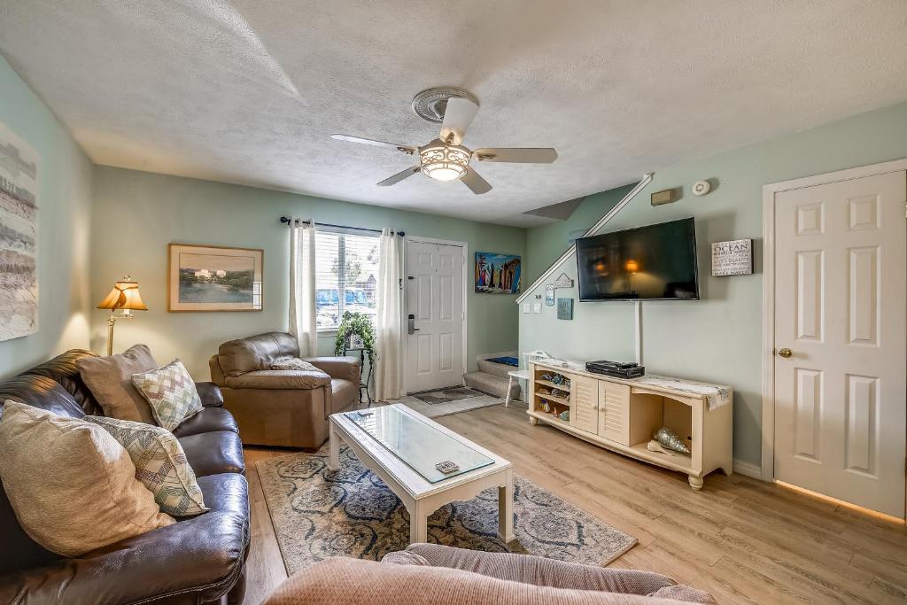a living room with a couch and a tv at 5 O'Clock Somewhere by Book That Condo in Panama City Beach