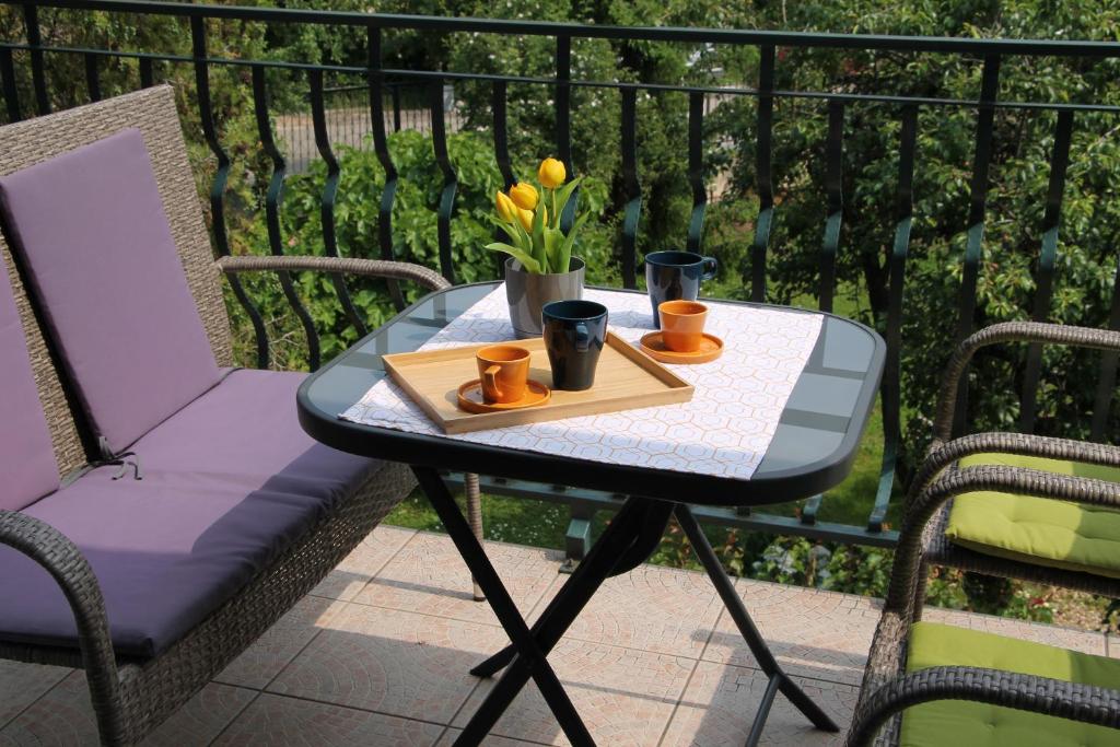 バラトンフレドにあるApartman Villa Magdalenaのテーブル(カップ2杯付)とトレイ(花付)