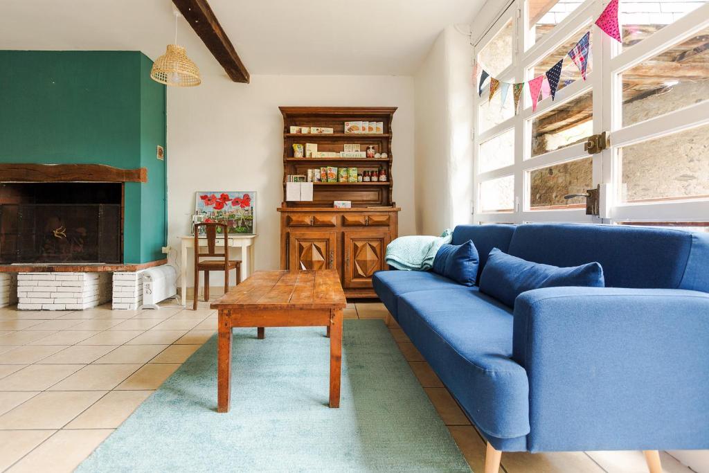sala de estar con sofá azul y mesa en Gite Tilia en Huos