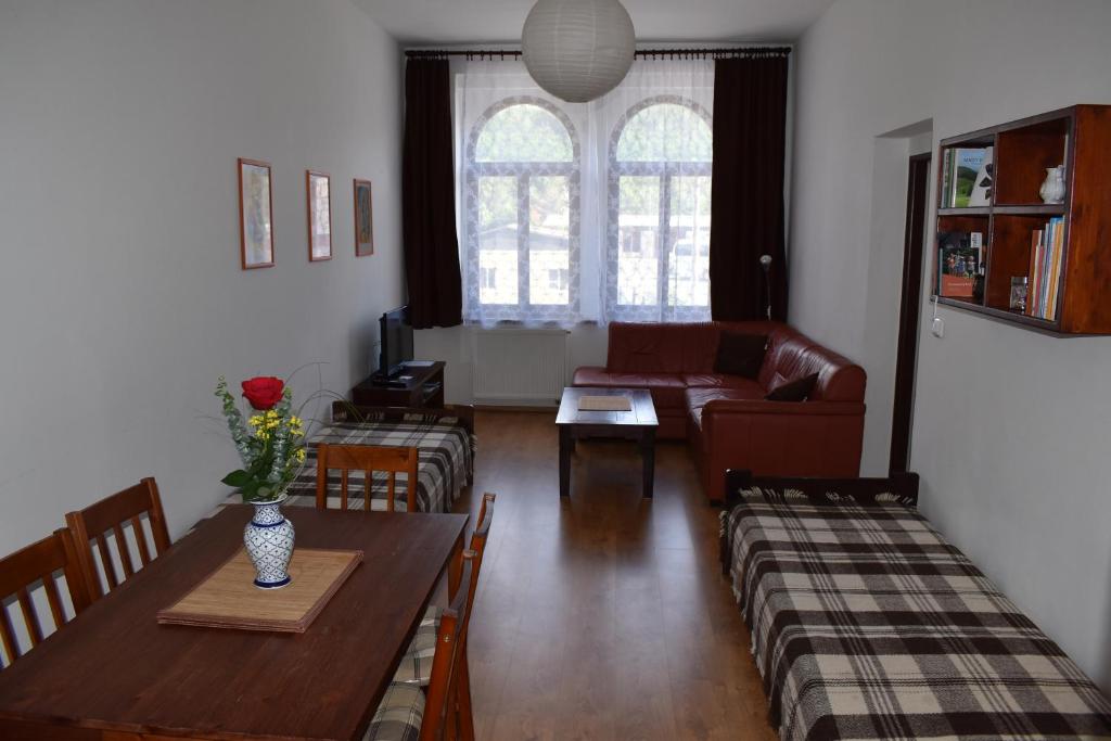uma sala de estar com uma mesa e um sofá em Apartmány Lenka em Karlovy Vary