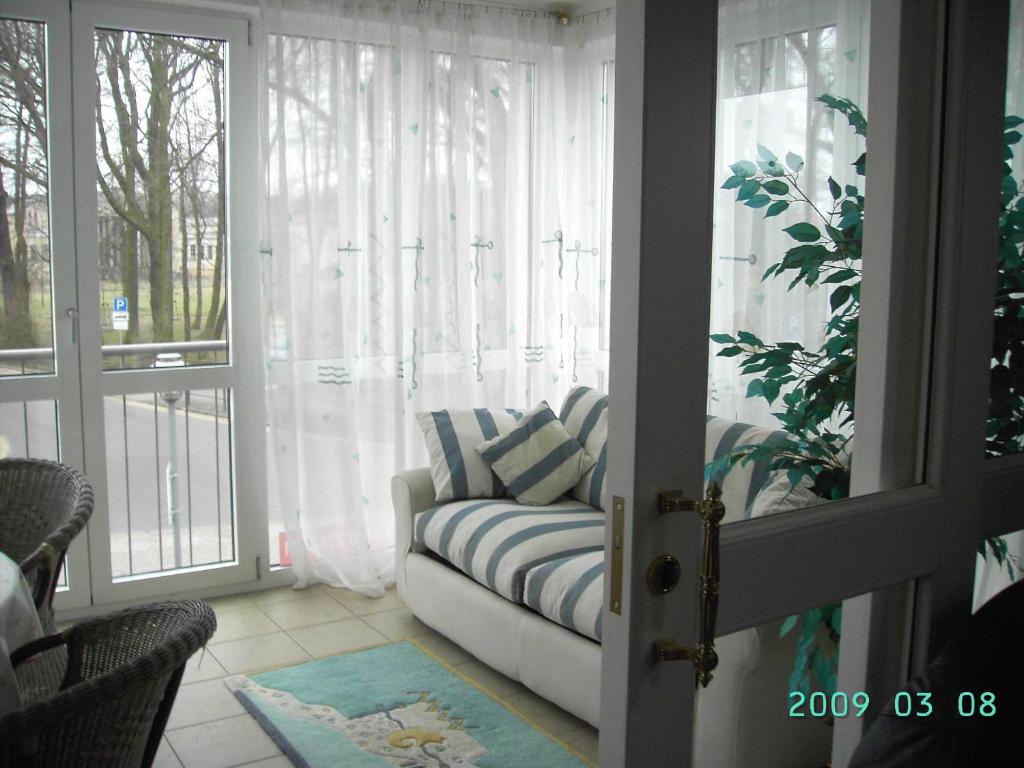 ein Wohnzimmer mit einer Couch vor einem Fenster in der Unterkunft Zinnowitz Residenz Sanssouci in Zinnowitz