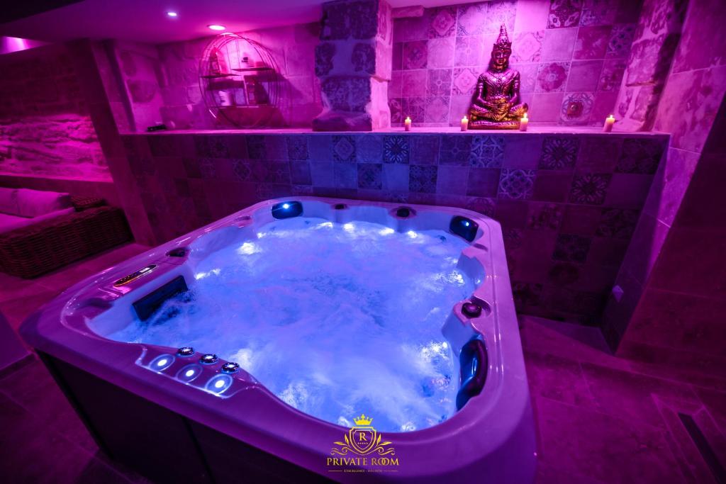 a purple bathroom with a jacuzzi tub at L'EXCELLENCE AVIGNON - Suite LUXE SAUNA, HAMMAM & JACCUZZI in Avignon