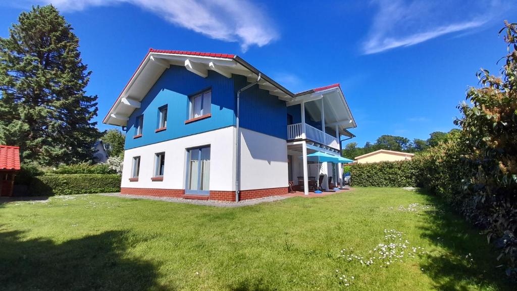 a blue and white house with a yard at Strandvilla Marius in Ostseebad Koserow