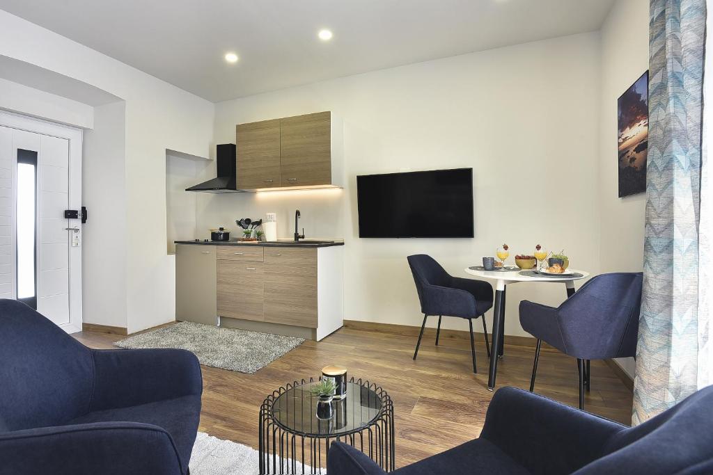 a living room with a table and a kitchen at D&A Central Luxury Apartments with FREE Parking in Pula