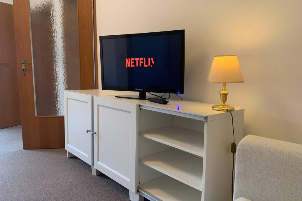 einen TV auf einer weißen Kommode in einem Zimmer in der Unterkunft Ruhiges zentral gelegenes Apartment in Gütersloh in Gütersloh