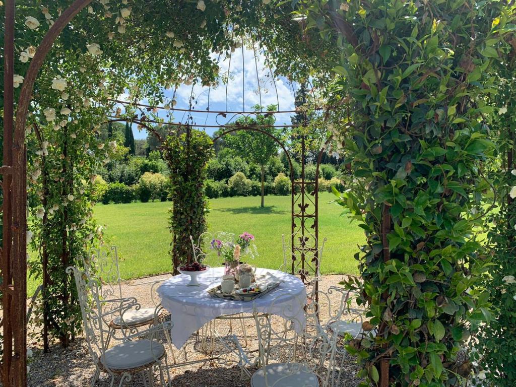 um arco com uma mesa e cadeiras num jardim em Country B&B Corniola em Empoli