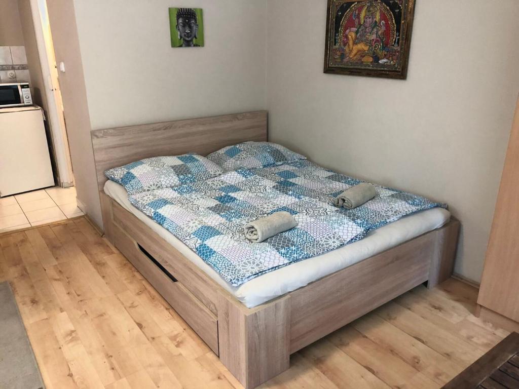 Bett mit einer Decke auf dem Zimmer in der Unterkunft Tulipán Apartman in Eger