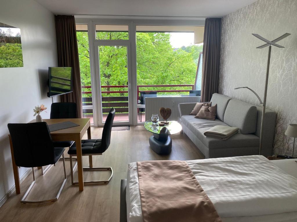 Un dormitorio con una cama, un escritorio y un sofá. en Appartement Ausblick Park, en Hahnenklee-Bockswiese