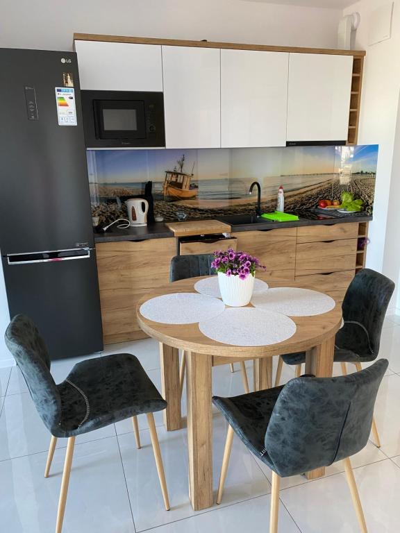 kuchnia ze stołem i krzesłami w kuchni w obiekcie MIĘDZYZDROJE,BALTICUS PROMENADA GWIAZD 14, Apartament z odrębnym salonem i sypialnią z Widokiem na morze w mieście Międzyzdroje