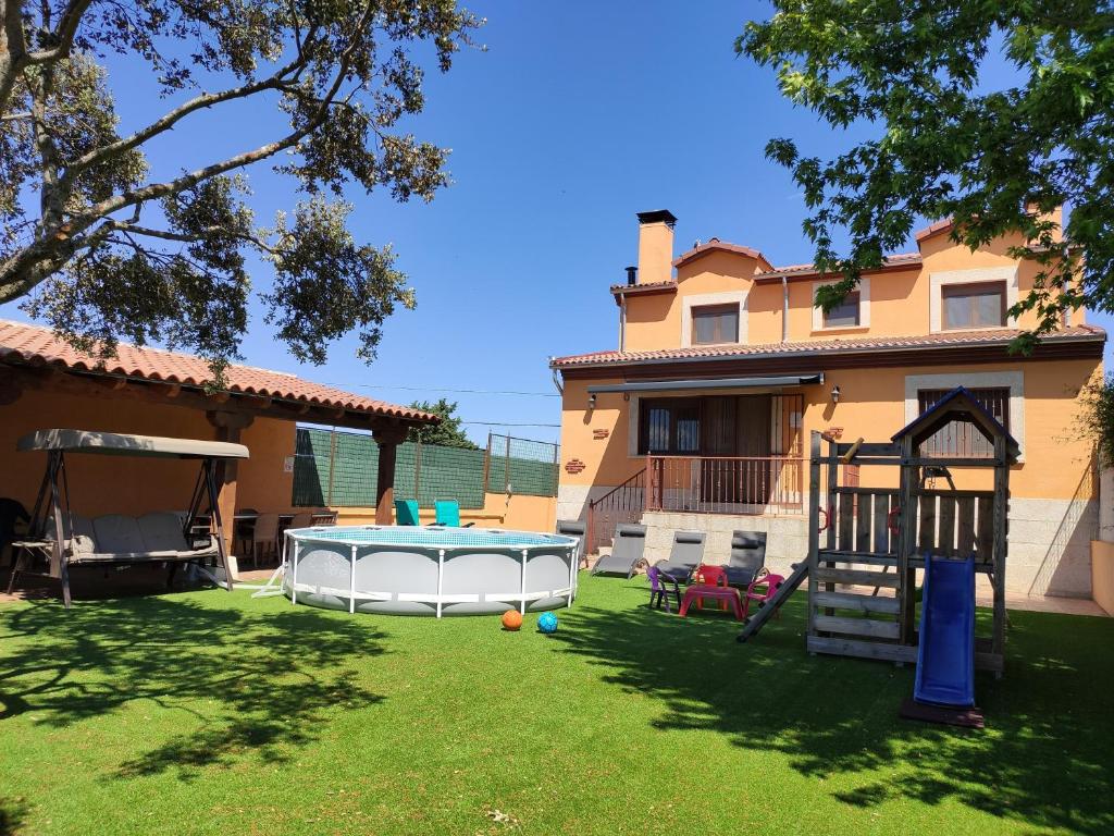um quintal com uma mesa de bilhar e uma casa em Casa Rural & SPA Mirador Sierra de Béjar em Guijo de Ávila