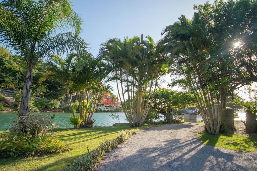 un parque con palmeras y un cuerpo de agua en Pousada Quinta da Margem, en Florianópolis