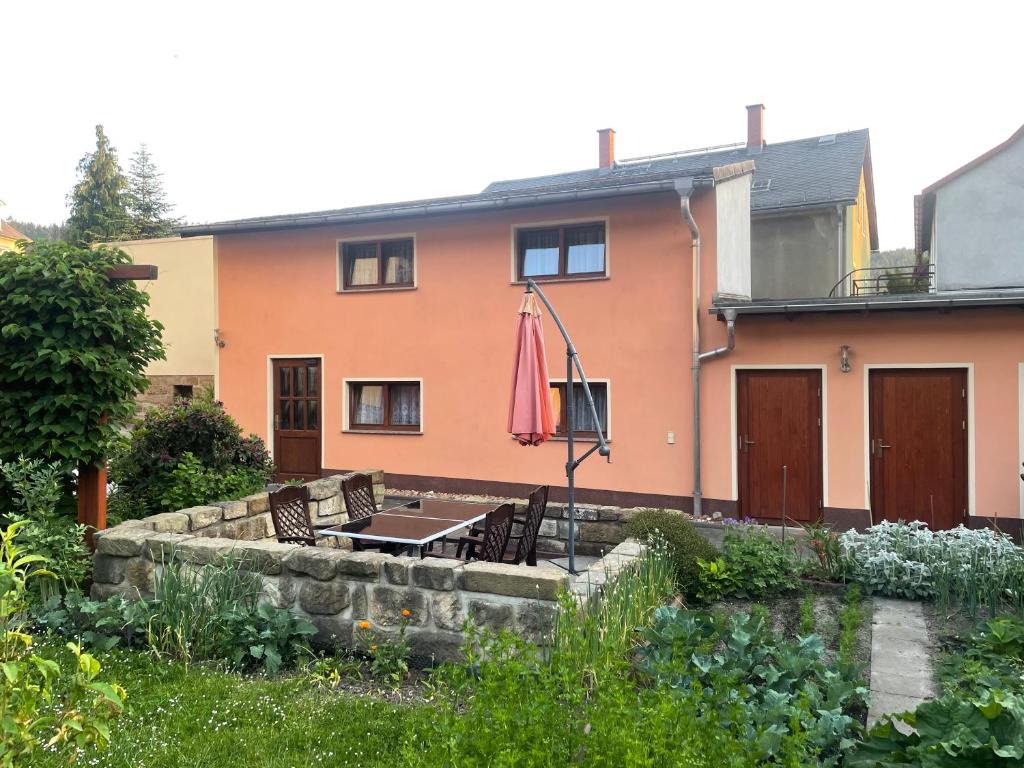 een huis met een tafel en stoelen in de tuin bij Ferienhaus Schmidt in Rathmannsdorf