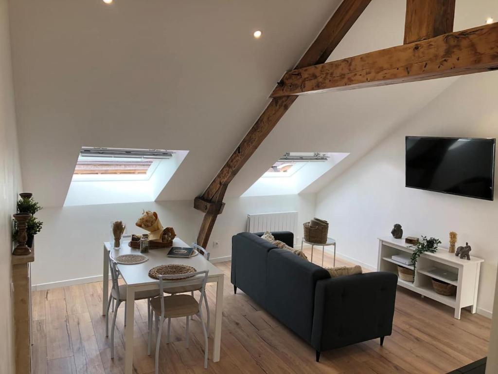 uma sala de estar com um sofá e uma mesa em Nouveau ! Appartement loft hyper centre Bayeux em Bayeux