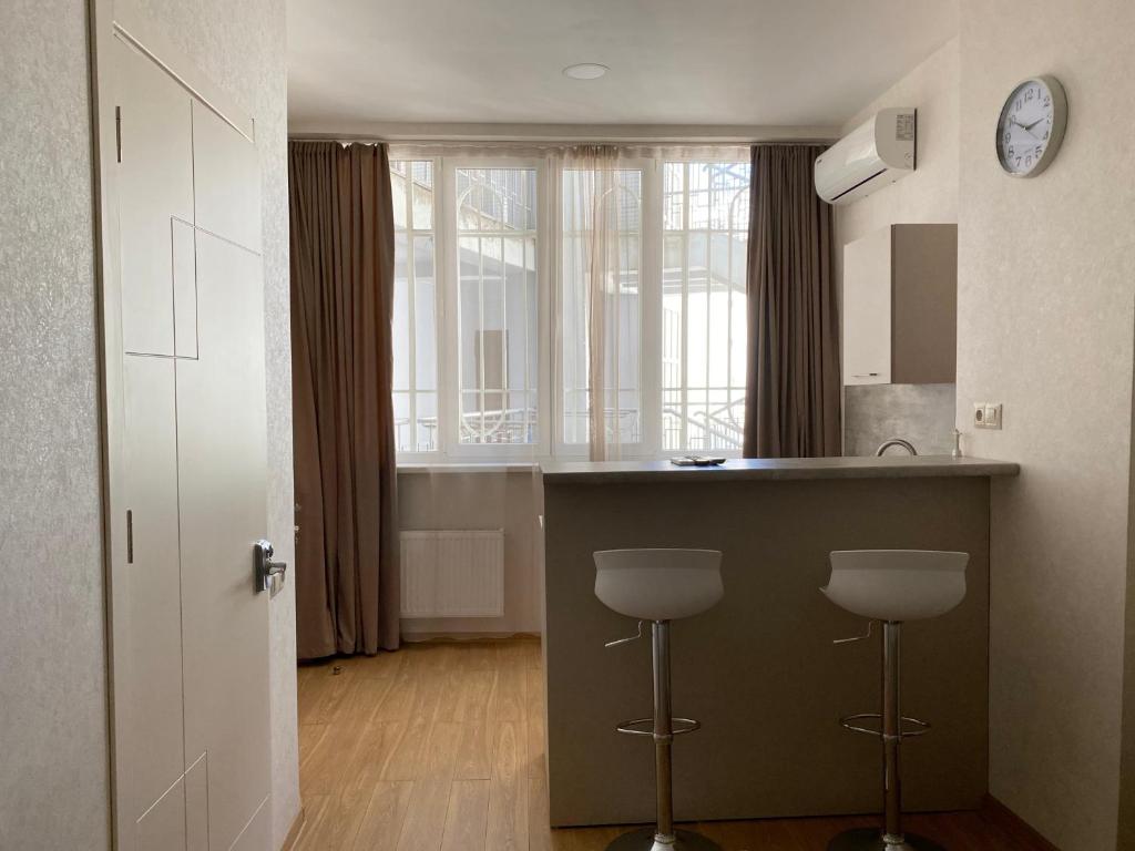 a kitchen with a counter and stools in a room at Liberty Apartment in Tbilisi City