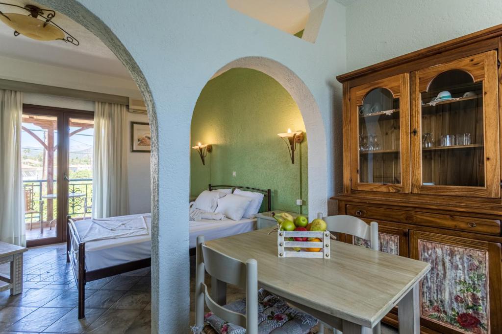 a room with a bed and a table with a dining room at Niriides Apartments in Stoupa