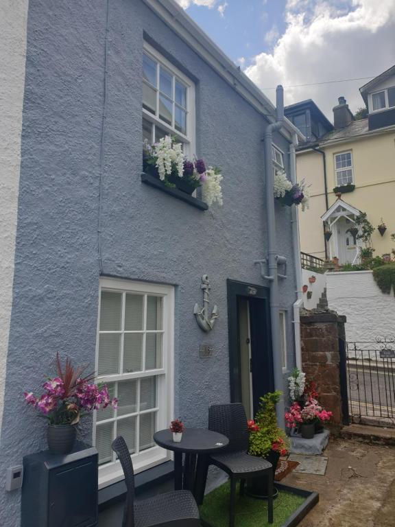 a blue house with a table and chairs in front of it at Anchor cottage in Brixham