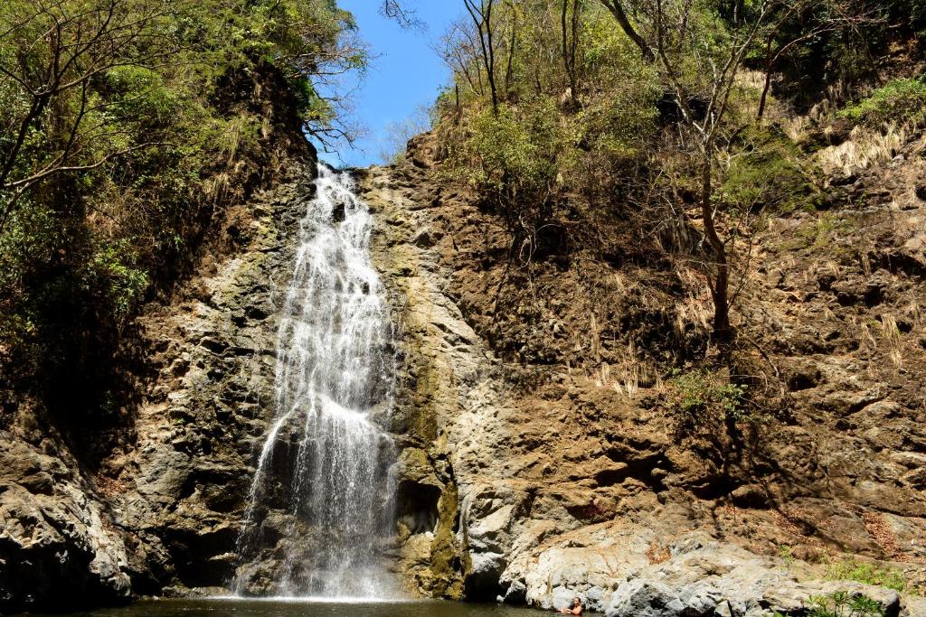 a waterfall on the side of a rocky cliff at Hotel La Cascada in Puntarenas