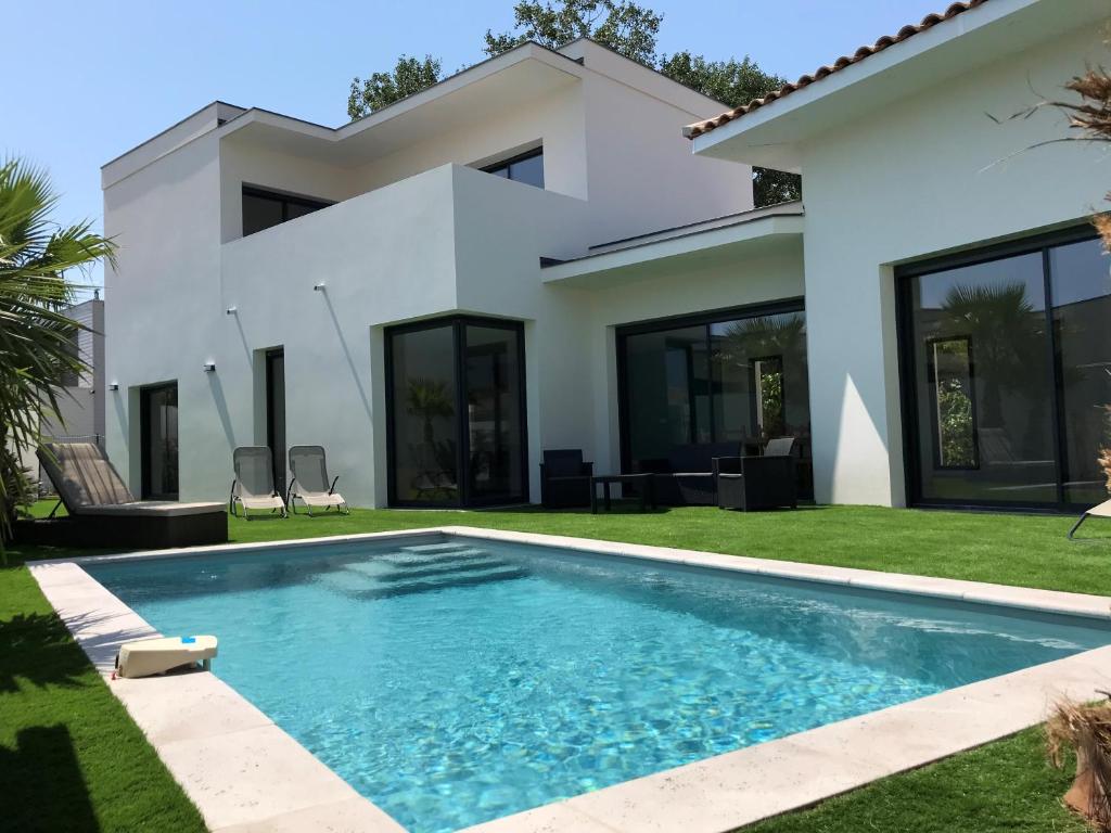 une villa avec piscine devant une maison dans l'établissement Villa MERYA piscine & plage, au Grau-dʼAgde