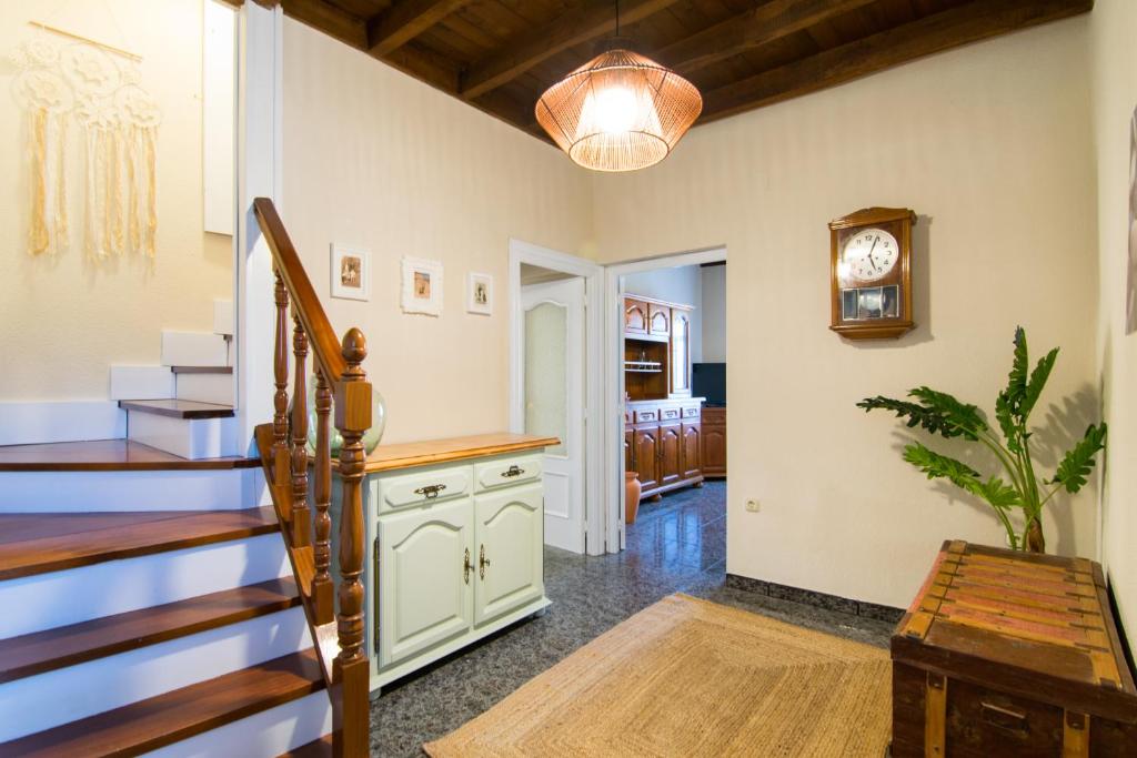 una habitación con una escalera y un reloj en la pared en Antiguo Horno de María y Mielgo, en Muelas del Pan