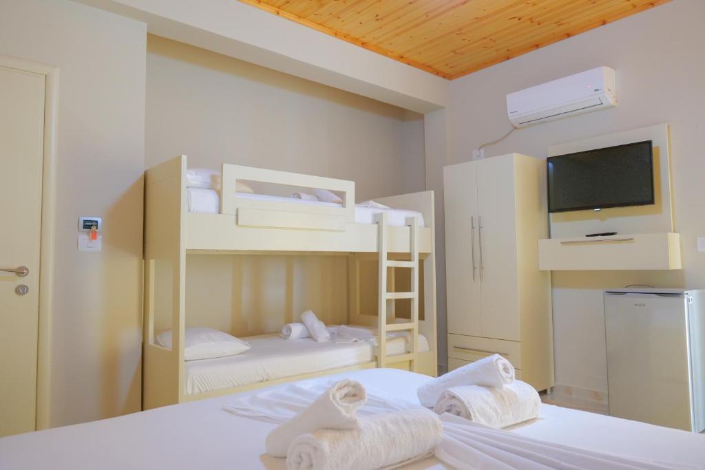 Pokój z 2 łóżkami piętrowymi i telewizorem w obiekcie Vila Balani w mieście Ksamil