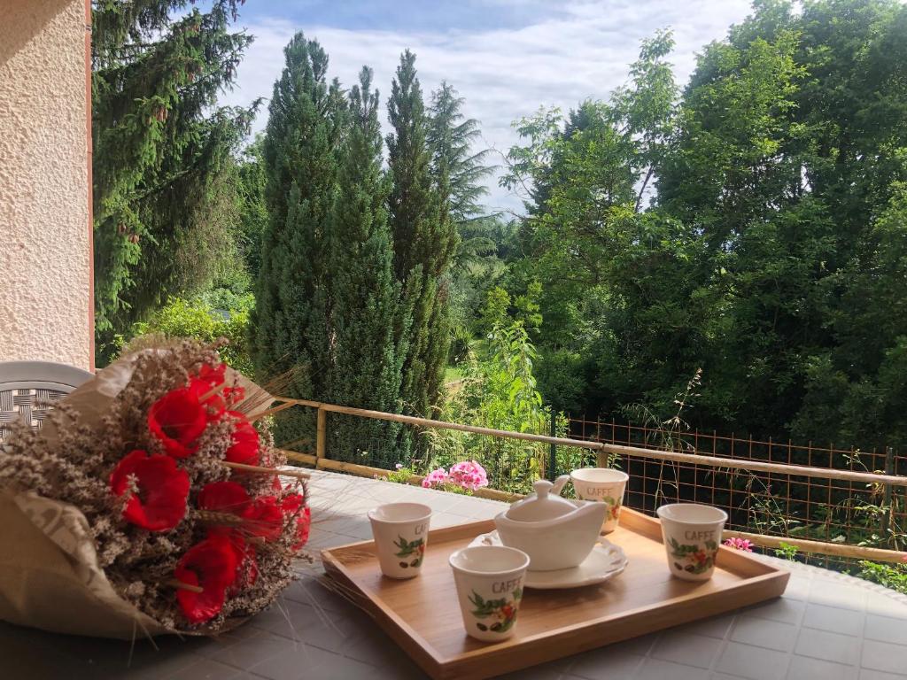 a table with cups and a tea set on a balcony at Il Bosco e Il Borgo Guest House Subiaco in Subiaco