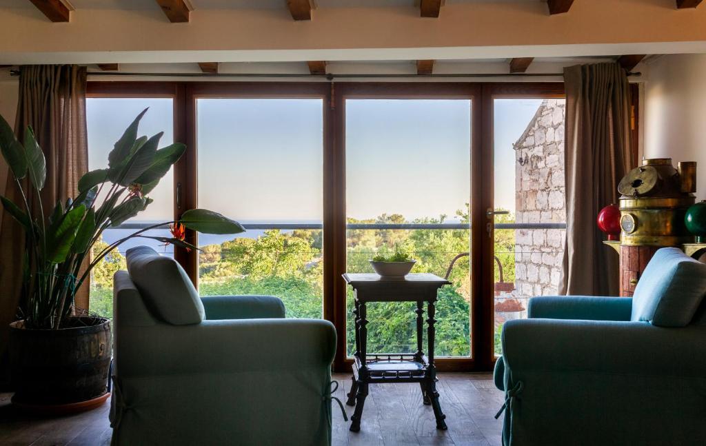 a living room with two chairs and a large window at Golden Summerhouse in Komiža