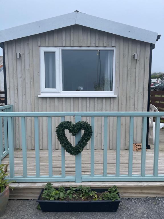 a heart sign on a fence in front of a house at Kevara Shepherds Hut in Finstown
