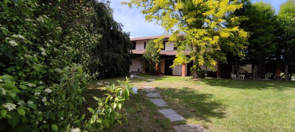 a house with a tree and a grass yard at Villa De Alberti in Vergiate