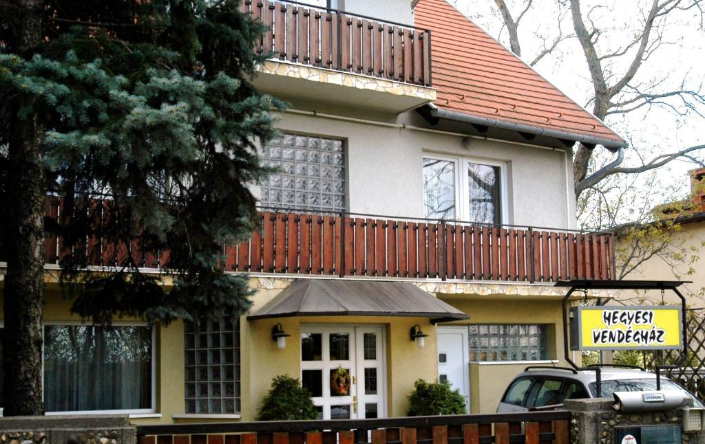 een groot huis met een balkon. bij Hegyesi Vendégház in Gödöllő