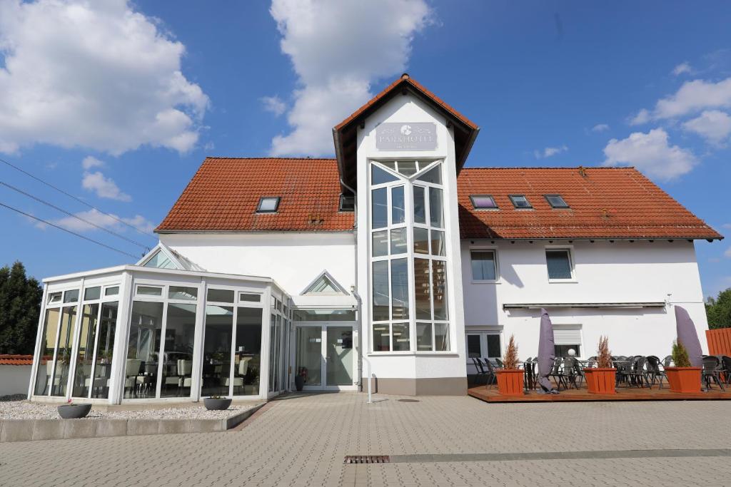 een groot wit gebouw met een rood dak bij Parkhotel am Schloss Machern in Machern