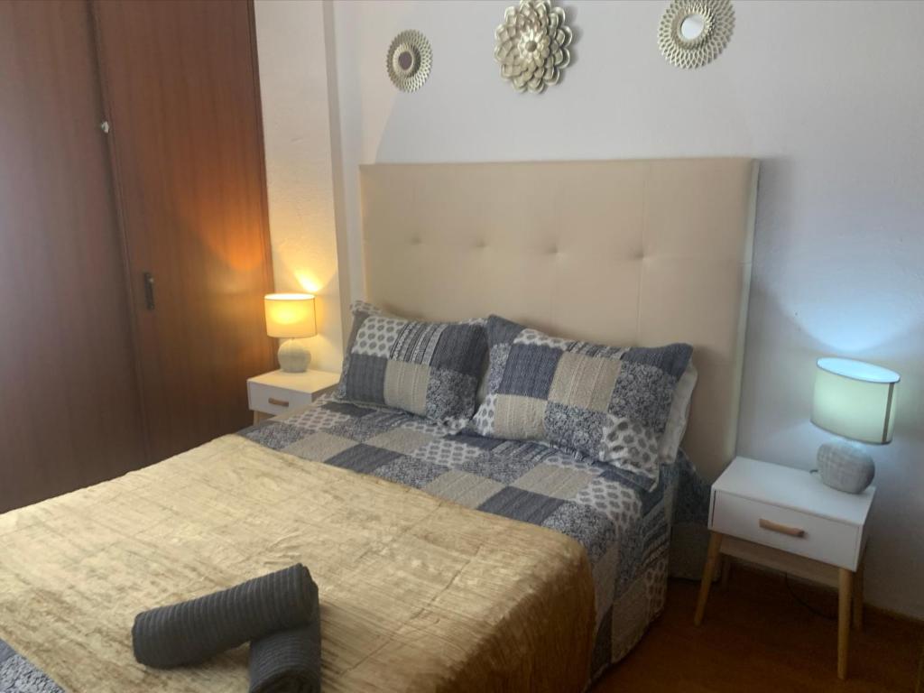 una camera con un letto con due comodini e due lampade di APARTAMENTO PERLA 5 PRIMERA LINEA DE PLAYA a Fuengirola