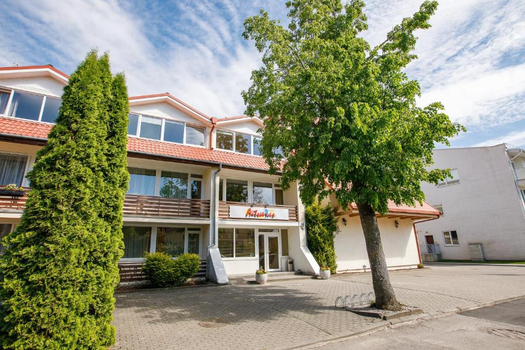 un bâtiment avec un arbre en face dans l'établissement Viešbutis Prie Fontano, à Palanga