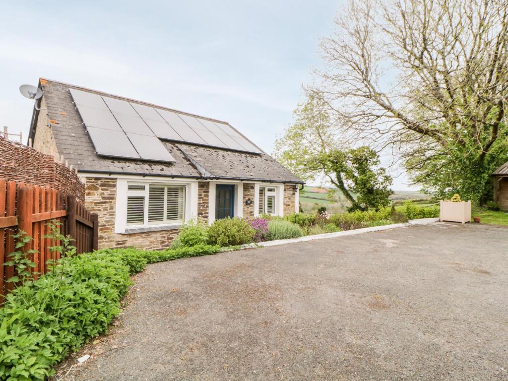 una casa con paneles solares en el techo en Meadowlea Cottage, en Plymouth