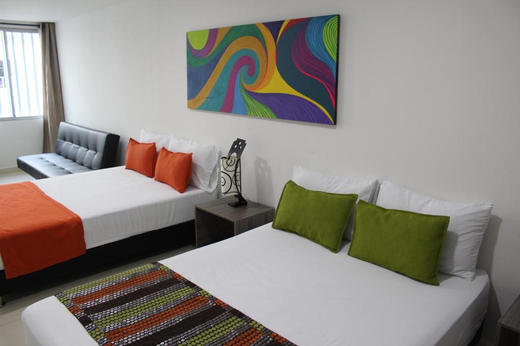 Habitación con 2 camas y una pintura en la pared. en Hotel Pereira 421, en Pereira