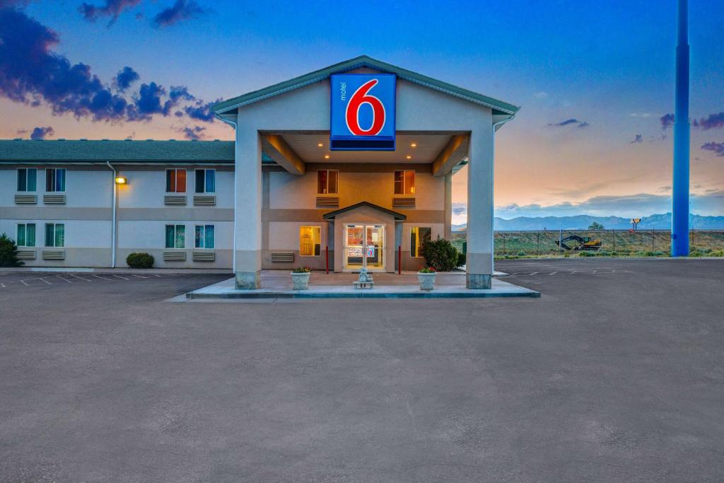 un hôtel avec un panneau numéro 6 dans un parking dans l'établissement Motel 6-Beaver, UT, à Beaver