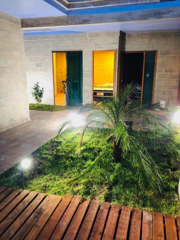 a house with a palm tree in front of it at Recanto Praia Grande in Arraial do Cabo