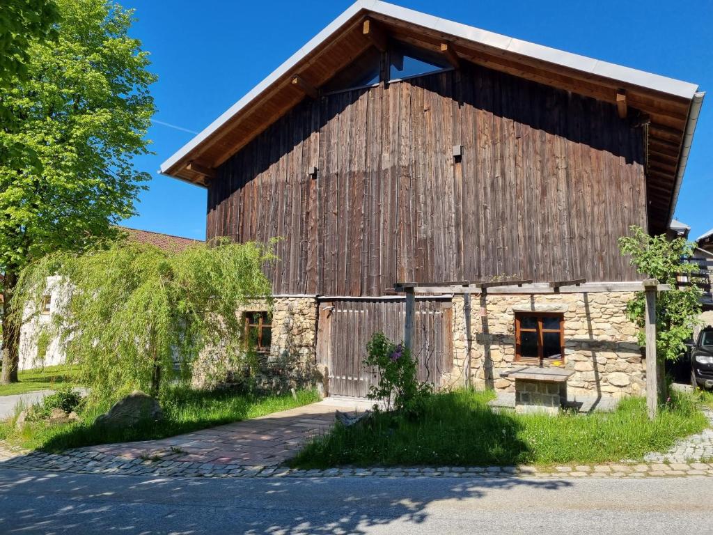 a large wooden barn with a gambrel roof at Ferienwohnung Kreuzberg in Freyung
