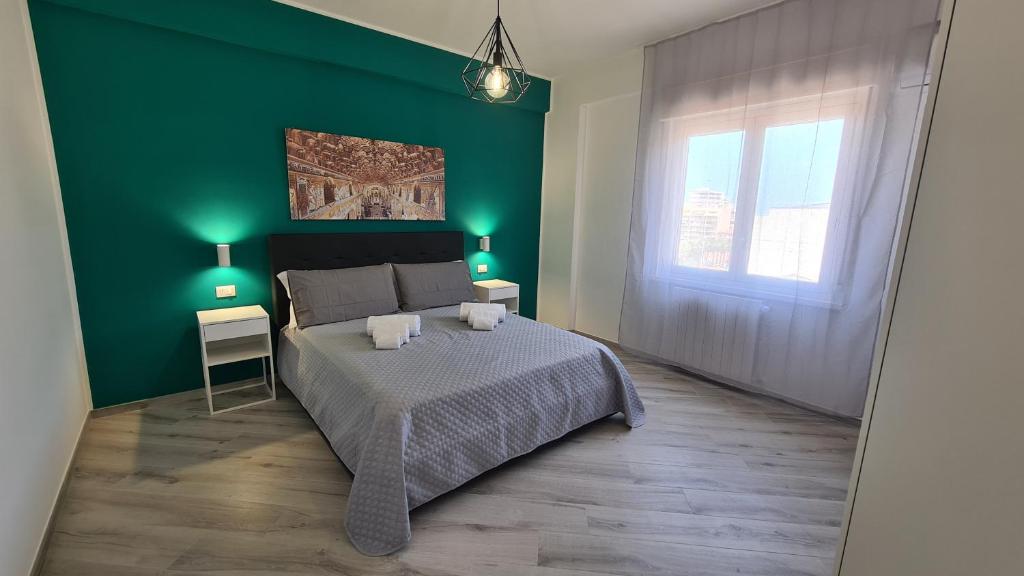 Dormitorio verde con cama y pared verde en Alberira Apartments, en Palermo