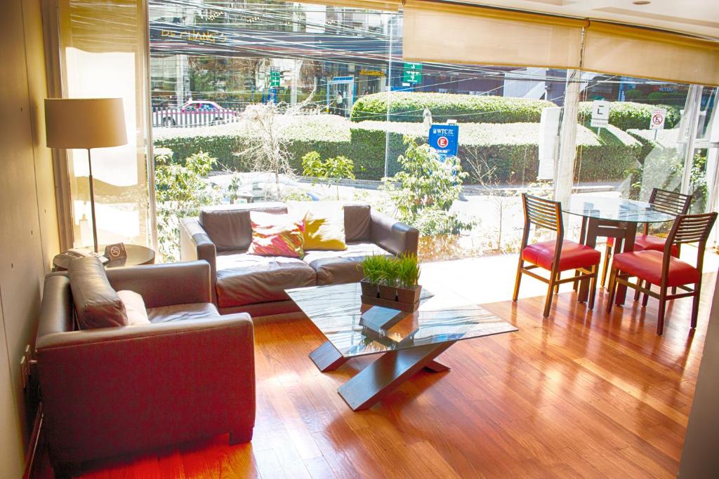a living room with a couch and a table and chairs at Suites Aura For Living in Mexico City