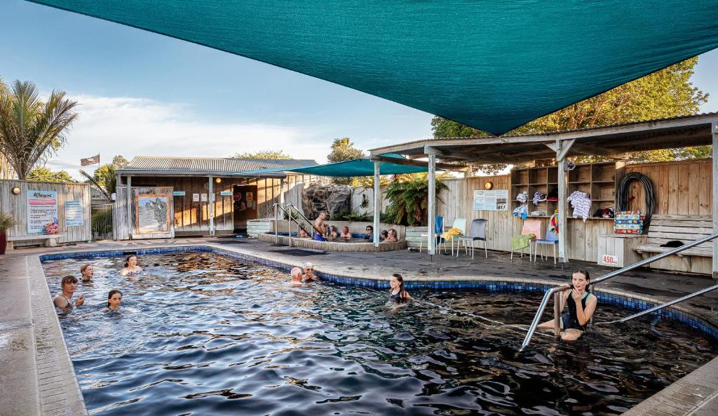 - un groupe de personnes se baignant dans une piscine dans l'établissement Athenree Hot Springs & Holiday Park, à Waihi Beach