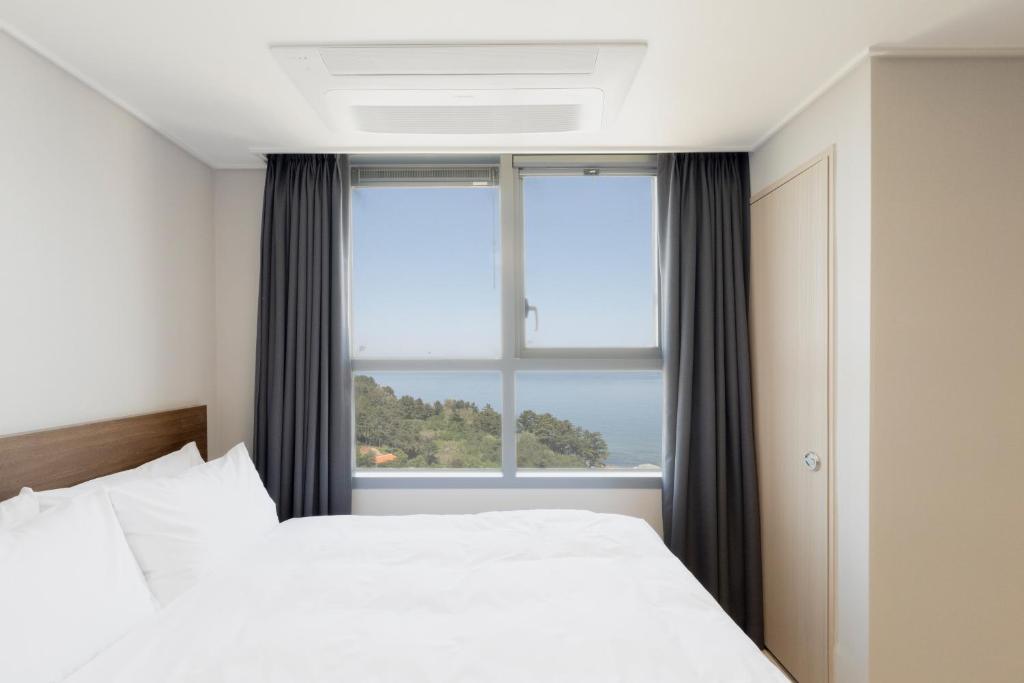 Postel nebo postele na pokoji v ubytování Donghae Oceancity Residence Hotel