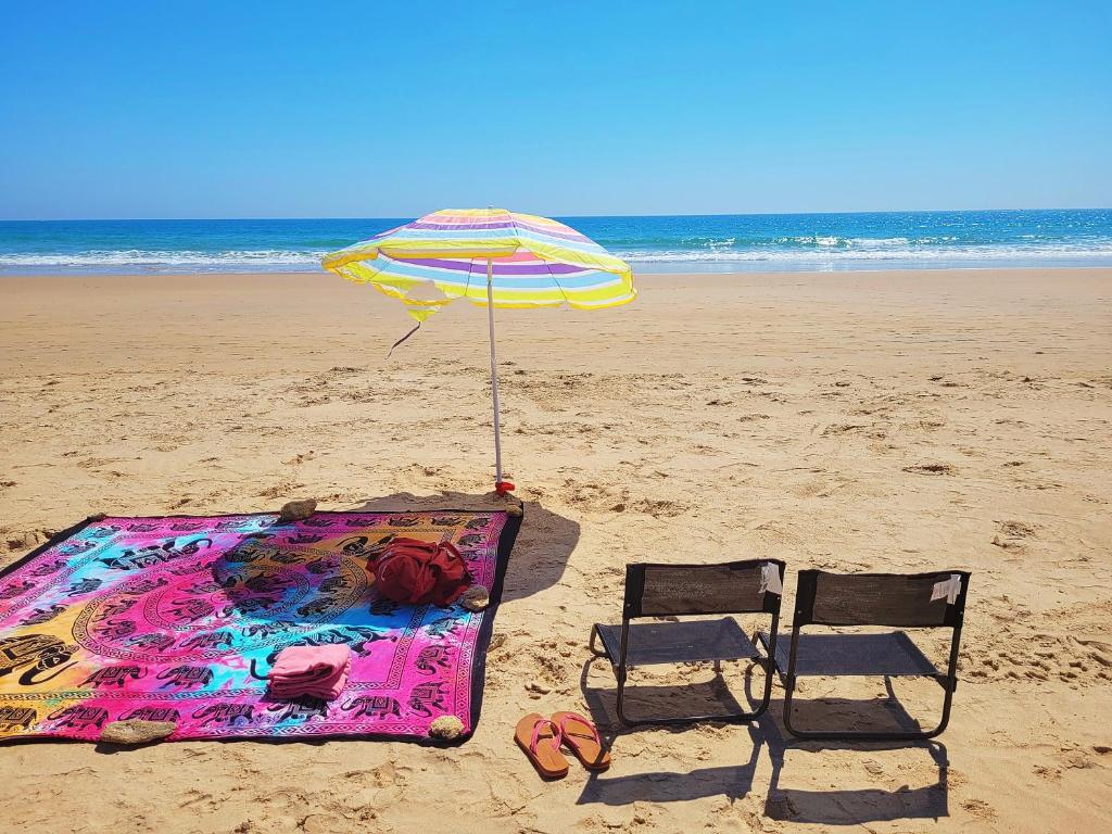 krzesło i parasol na plaży w obiekcie Cozy Chalet - playa a 200m w mieście Chiclana de la Frontera