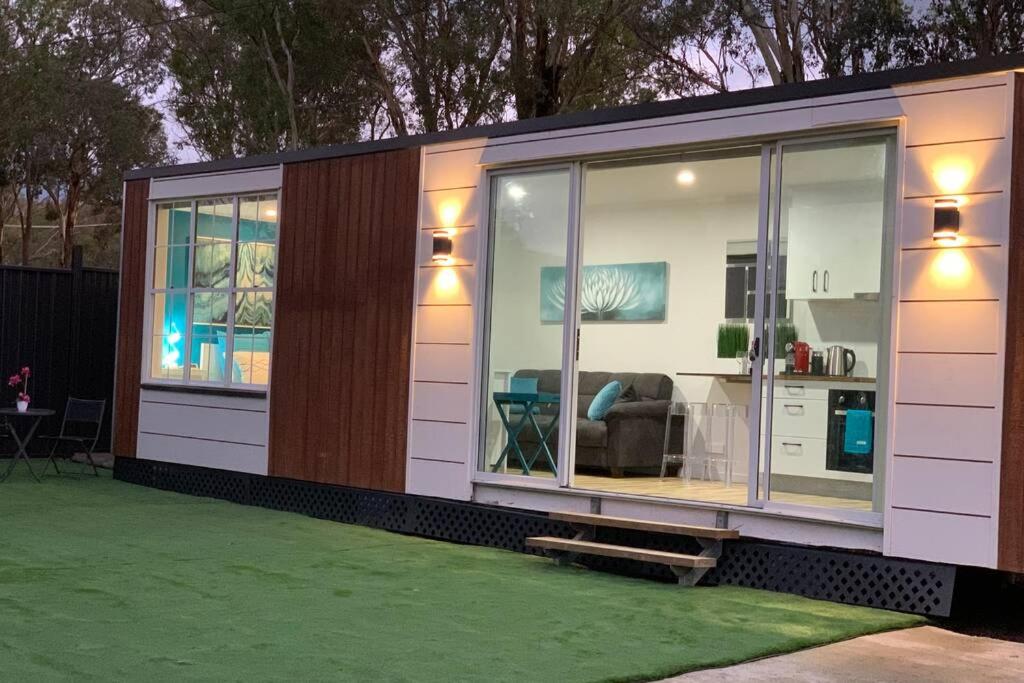 a small house with glass doors and a living room at Tiny House in Belconnen 1BR Self Contained Wine in Higgins