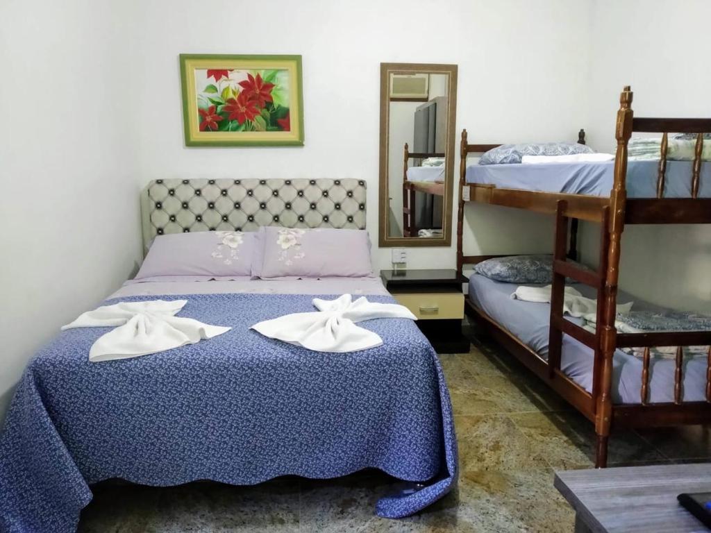 a bedroom with a bed and two bunk beds at Pousada Pier 123 in Penha