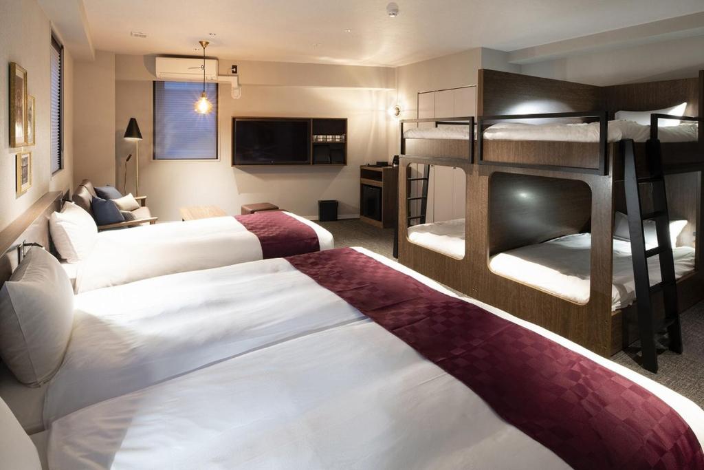 une chambre d'hôtel avec 2 lits et des lits superposés dans l'établissement ALPHABED INN 小樽駅前, à Kita-hamachō